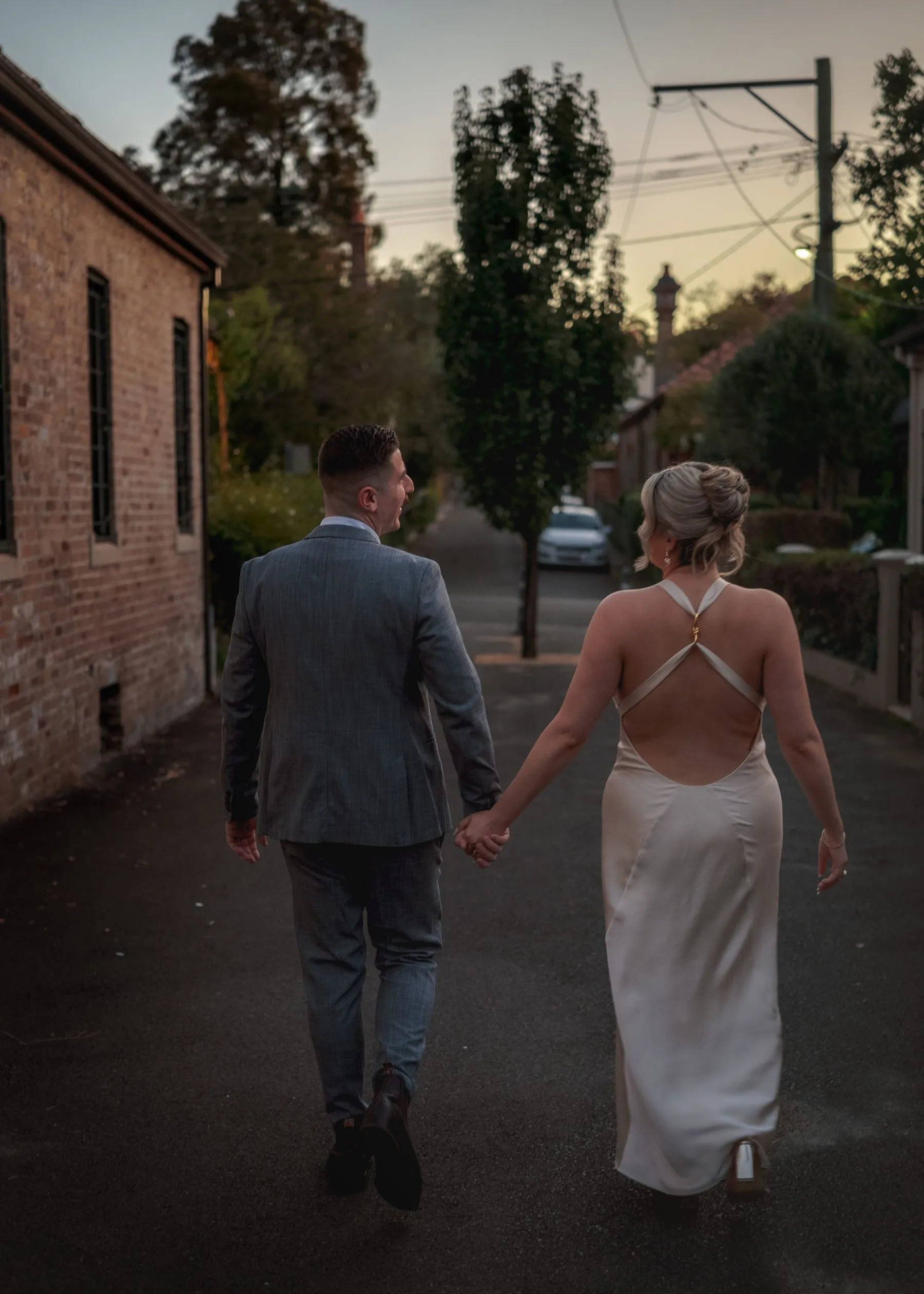 Wedding party laughing together at arched window, Sydney CBD